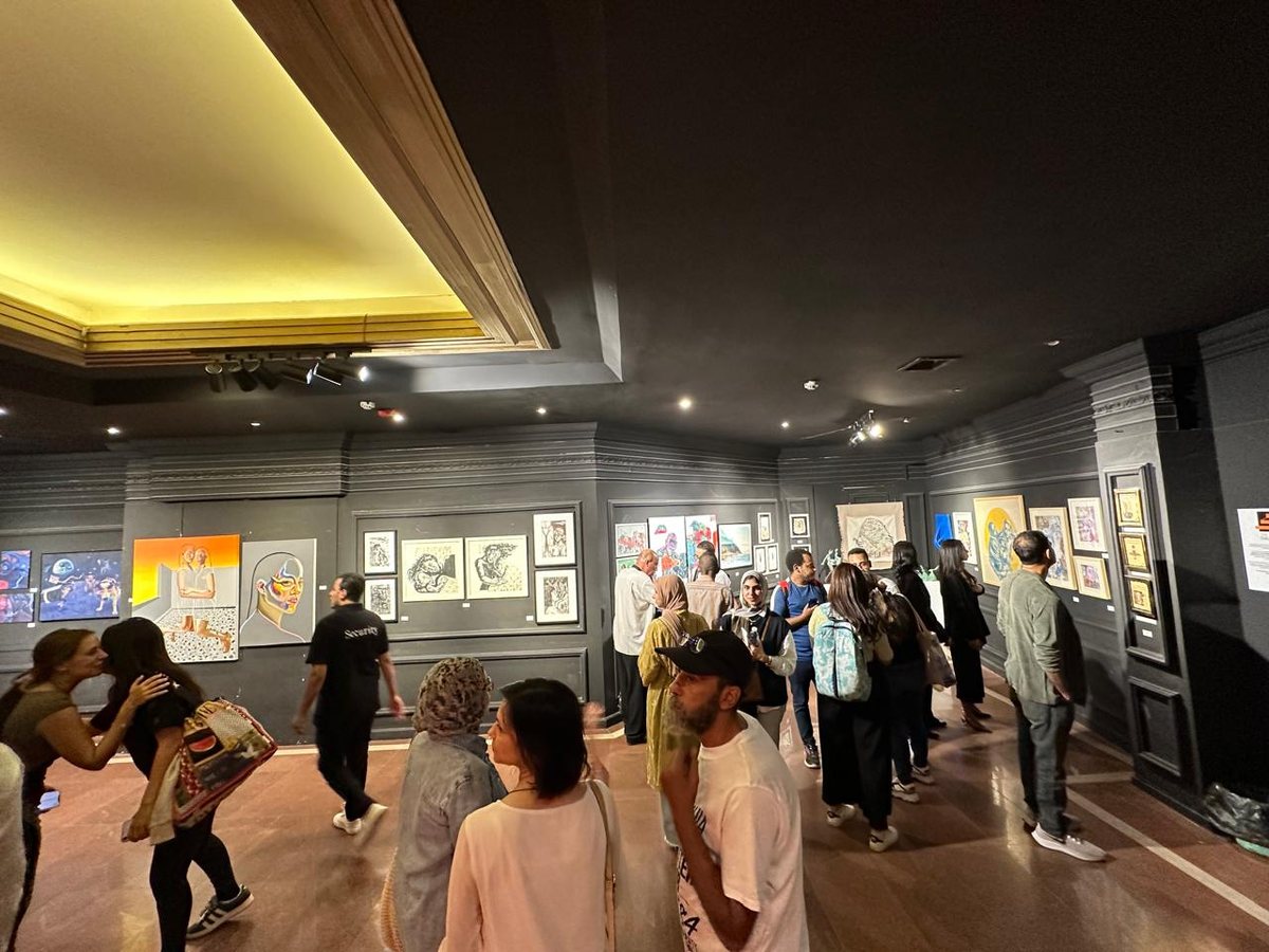 Visitors moving through a dark-walled exhibition hall at CIAD 4